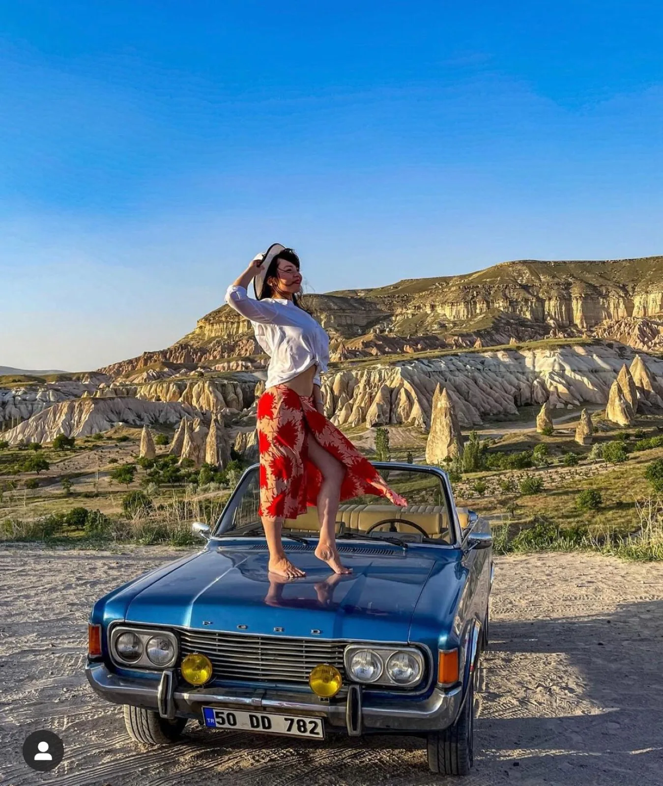 Vintage car with hot air balloons at sunrise in Cappadocia